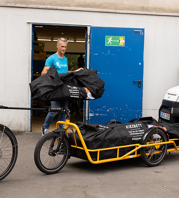 Lastenradfahrer verlädt Kiezbett in Repack Verpackungstaschen